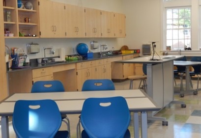 Bright classroom featuring blue chairs and tables