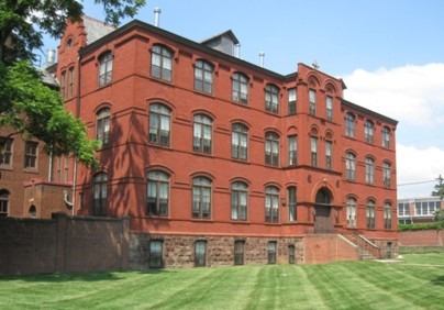 Historic red brick building with arched windows and a large entrance