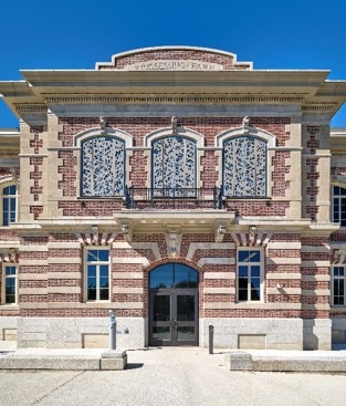 Historic red brick building featuring intricate window designs and decorative stone accents